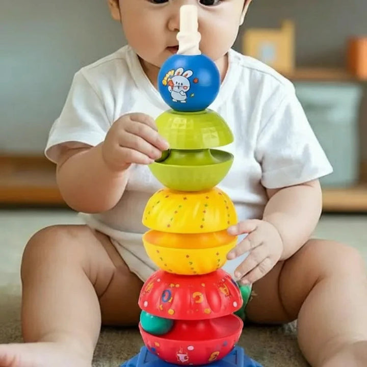 Child grasping a green piece on the colorful stacking tower