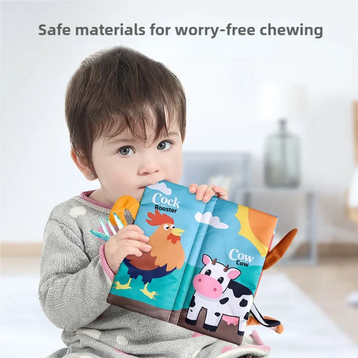 Child holding an open cloth book with rooster and cow illustrations