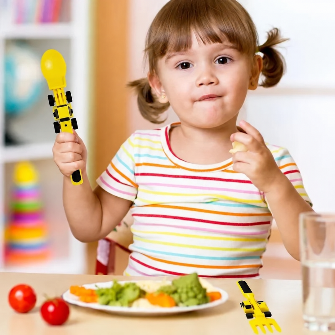 Child in a striped shirt holding a yellow construction-vehicle spoon at the table.
