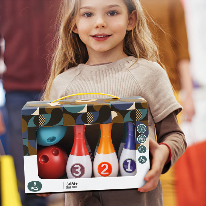 Child holding a boxed bowling set labeled 8 pieces and ages 36 months and up.