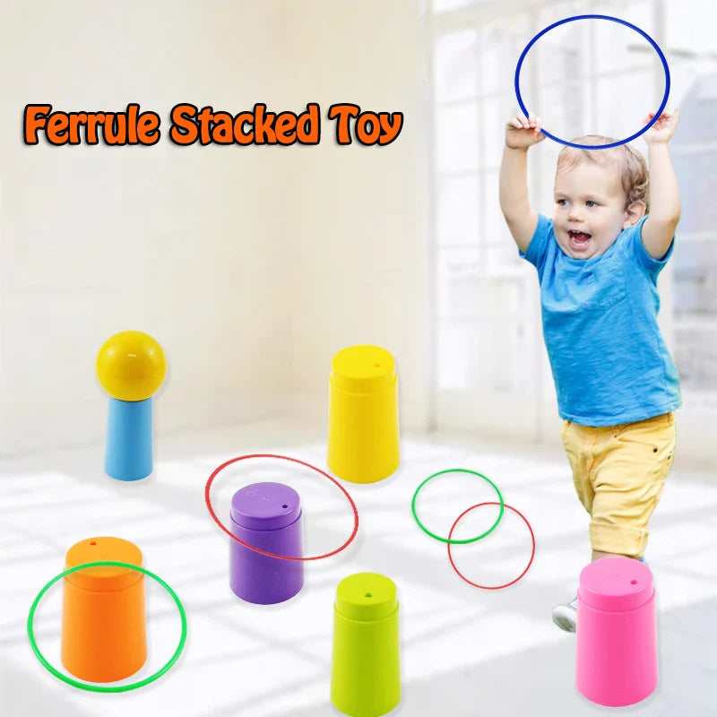 Child holding a blue ring overhead beside colorful tower pieces arranged on the floor