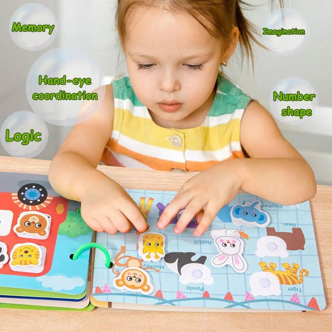 Child matching animal cards to outlines on an open busy book