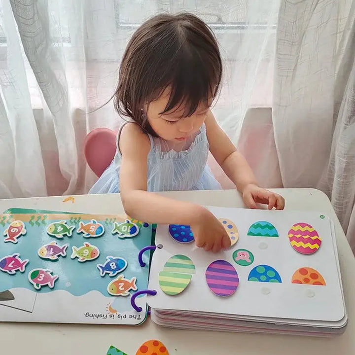 Child placing a patterned matching piece on an open activity book