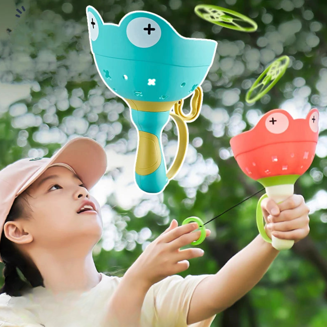 Child playing outdoors with frog-shaped disc launchers and green flying discs