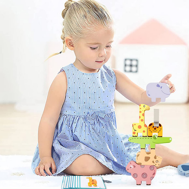 Child adding a purple hippo block to a colorful animal tower with pattern cards nearby