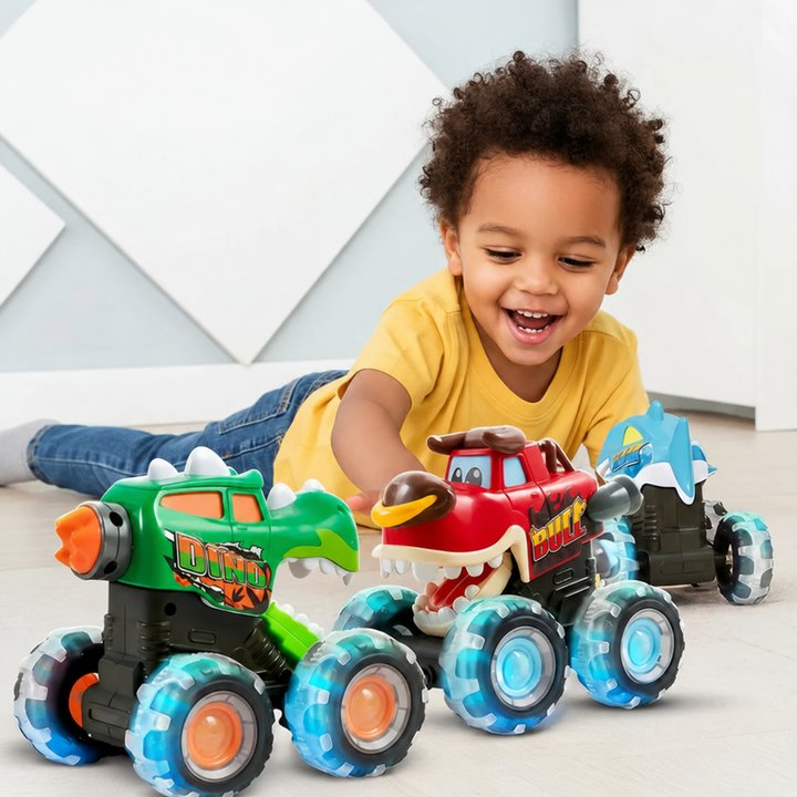 Child playing on the floor with green, red, and blue creature-themed monster trucks