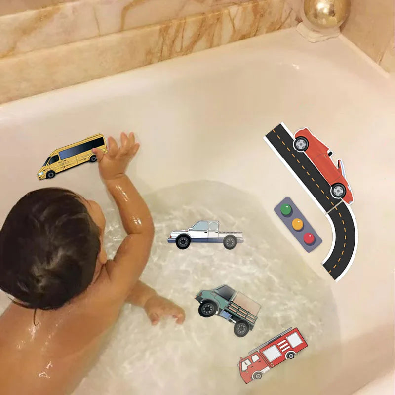 Child playing in the tub with foam vehicles and road pieces on the bathtub wall