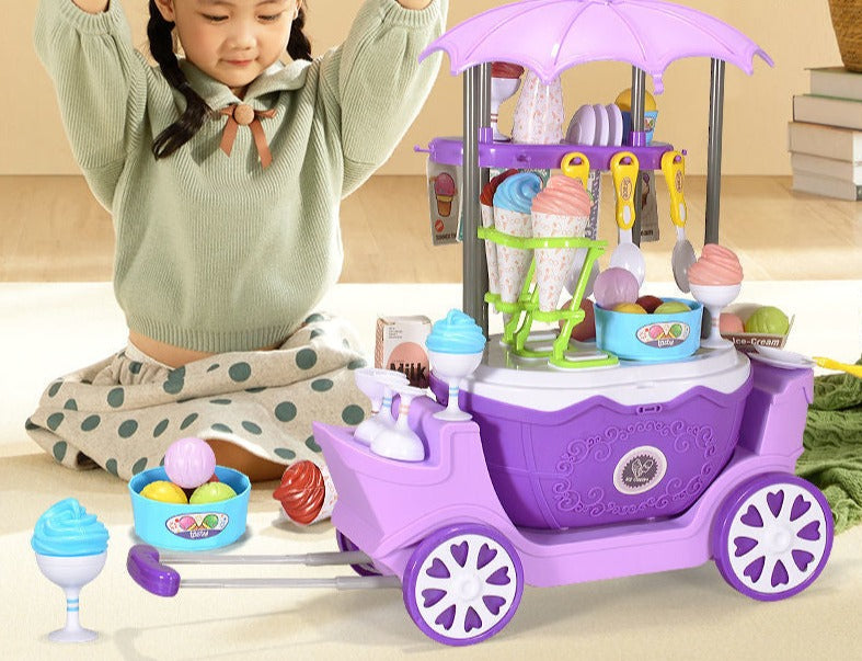 Child playing with a purple ice cream cart and pretend dessert accessories