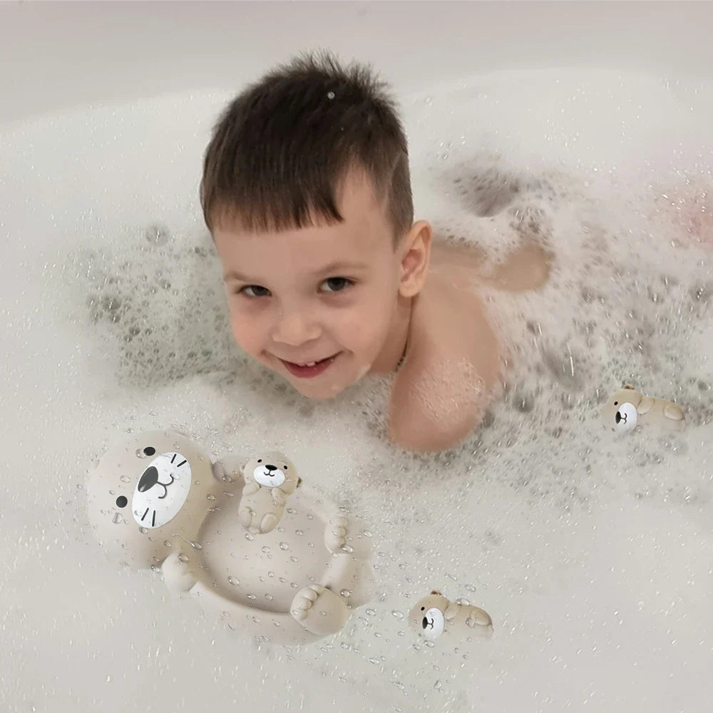 Child playing with the otter family bath toys in a bubble bath
