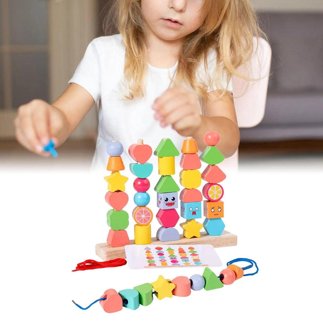 Child playing with colorful wooden beads beside a stacking stand, pattern card, and threading cord.