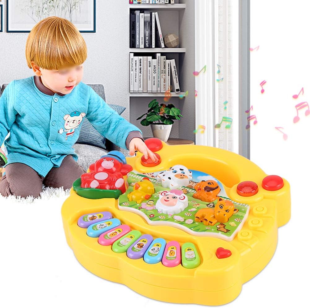 Child reaching for the animal buttons on a yellow toy piano with multicolored keys.