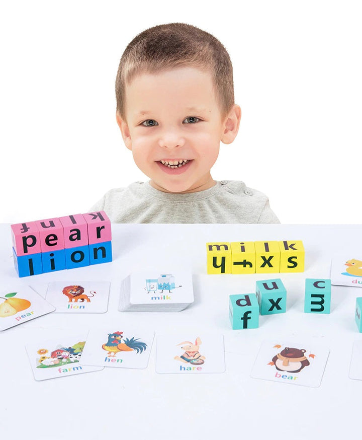 Child behind a tabletop display of letter blocks and illustrated word cards