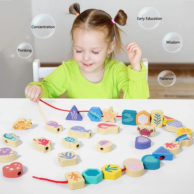 Child threading colorful wooden beads onto a red lacing cord at a table.