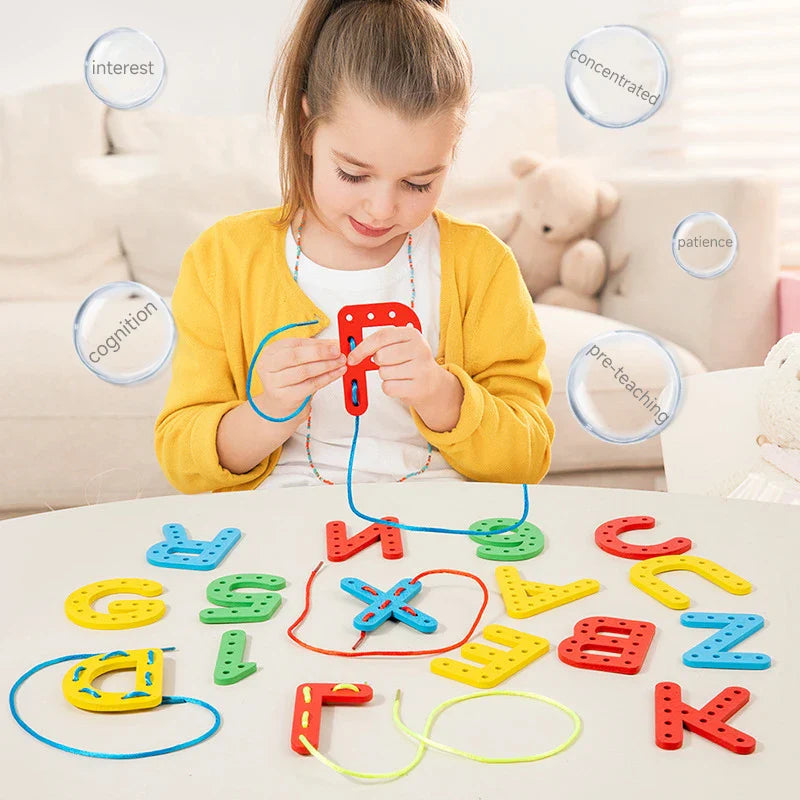 Child threading a blue cord through a red wooden letter at a table