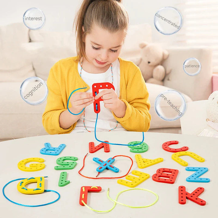 Child threading a blue cord through a red wooden letter at a table