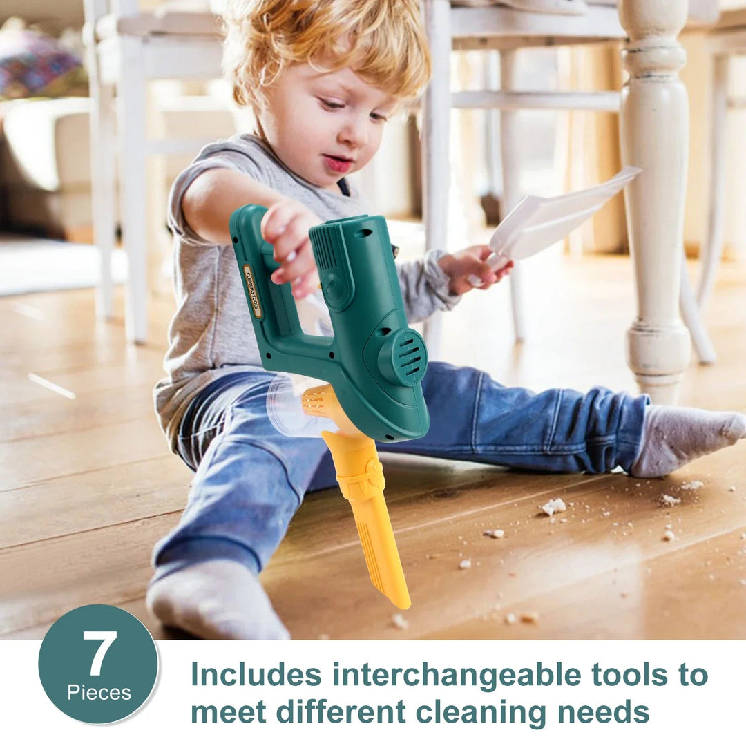 Child using the green handheld toy vacuum with a yellow narrow nozzle on a wooden floor