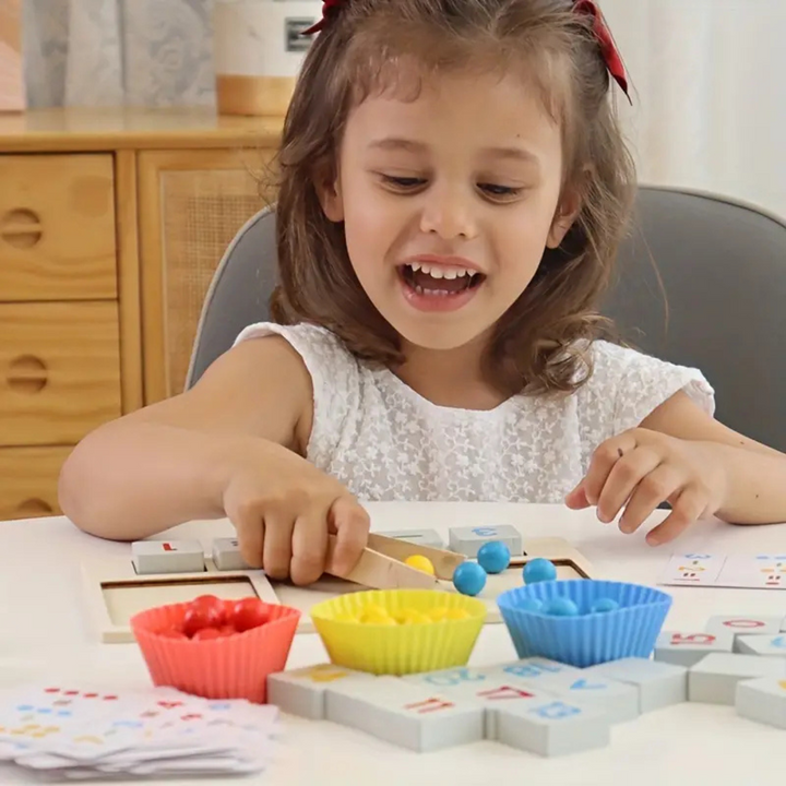 Child using tweezers to move counting beads between colorful sorting bowls