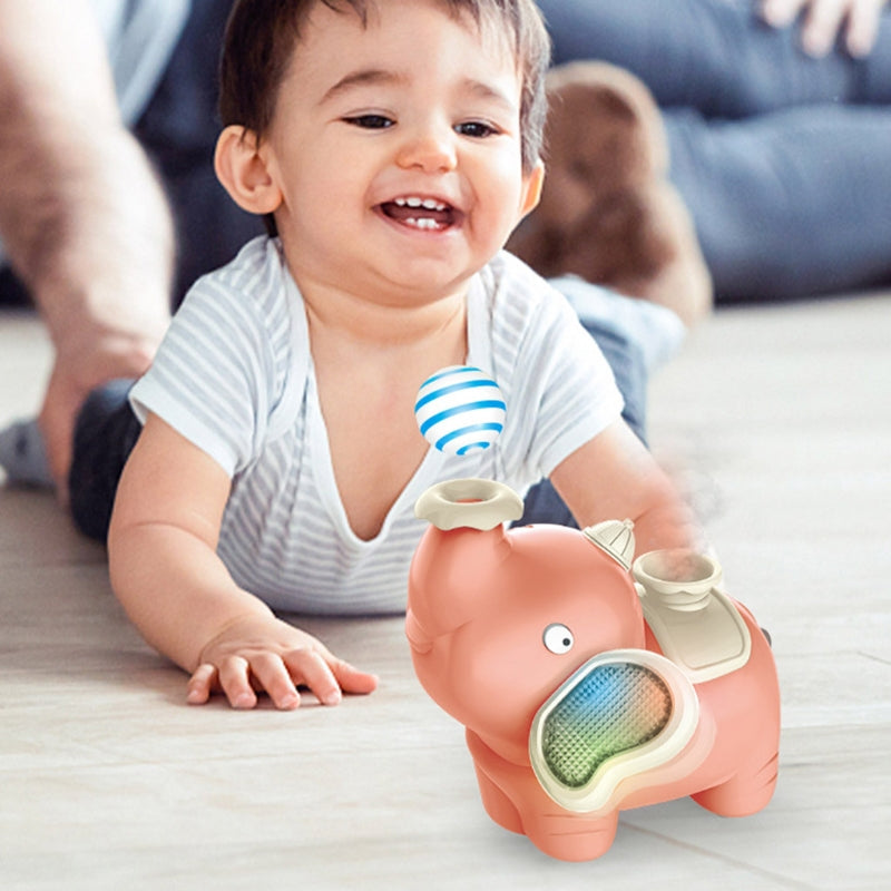 Child watching a pink elephant toy with a blue-and-white striped ball above its trunk.