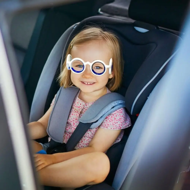 Child wearing white lens-free travel glasses while seated in a car seat