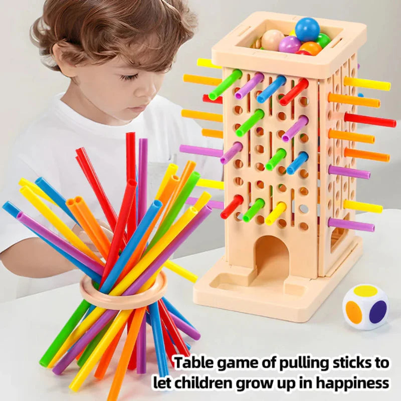 Child beside a ball-filled tower, ring-supported sticks, and a color-coded die