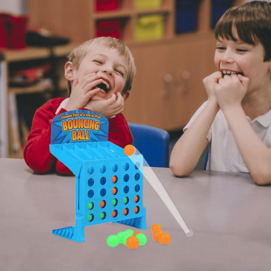 Two children laughing beside a blue ball toss game on a table