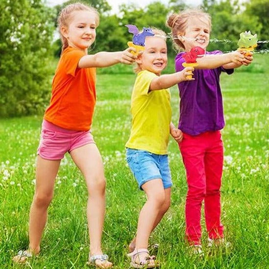 Three children playing outdoors with colorful dinosaur water guns.