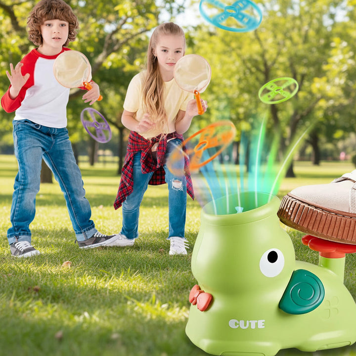 Children playing outdoors with catching nets, colorful flying discs, and a green foot-powered launcher