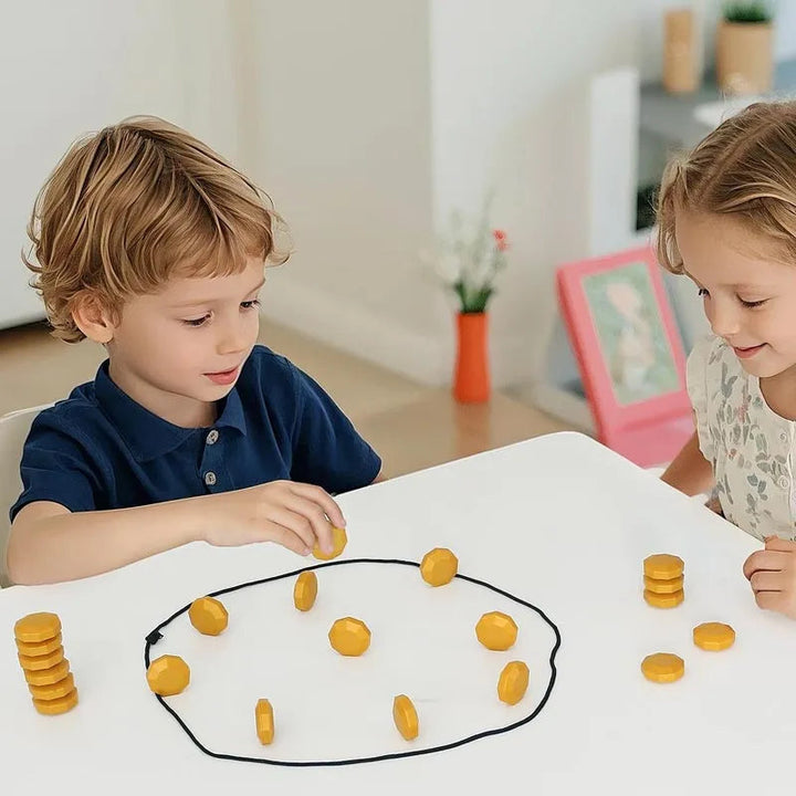 Two children playing with gold magnetic stones inside a cord loop