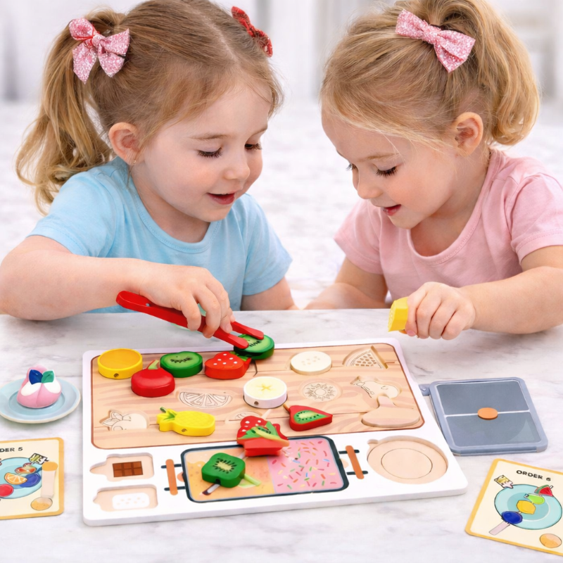 Two children playing with wooden fruit pieces and red tongs at the sorting board