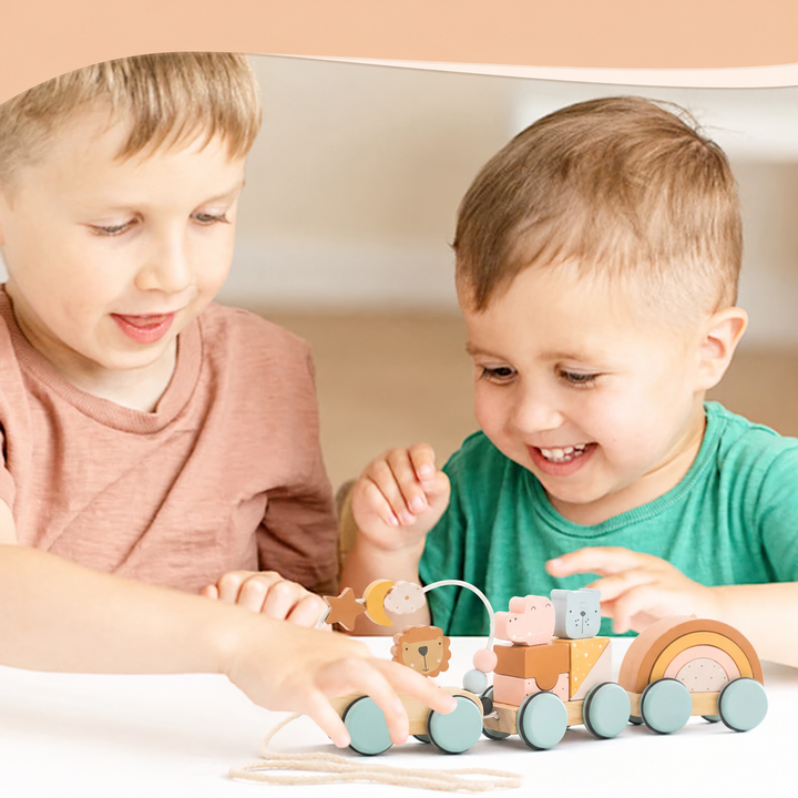 Two children playing with a wooden train with animal blocks and rainbow arches