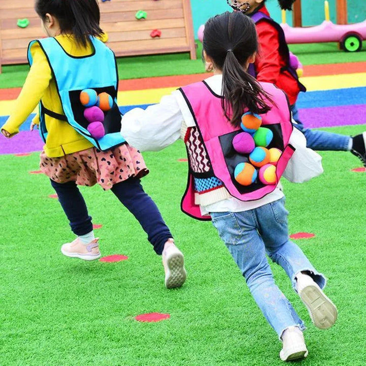 Children running outdoors in colorful vests with balls attached to the back panels