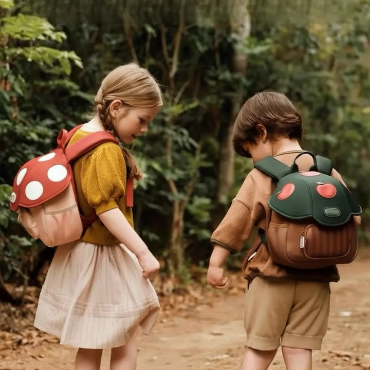 Children wearing the red Mushroom and green Apple Tree backpacks on an outdoor outing.