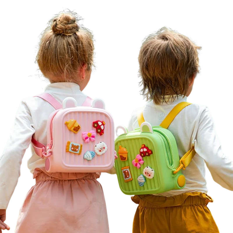 Rear view of two children wearing pink and green backpacks