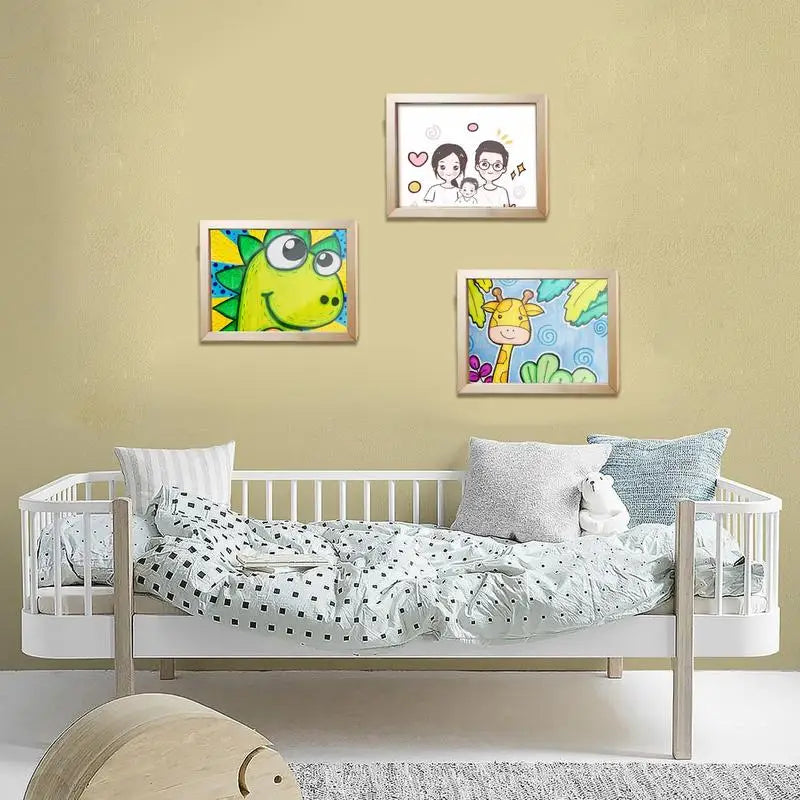 Three wooden art frames displaying drawings above a child&