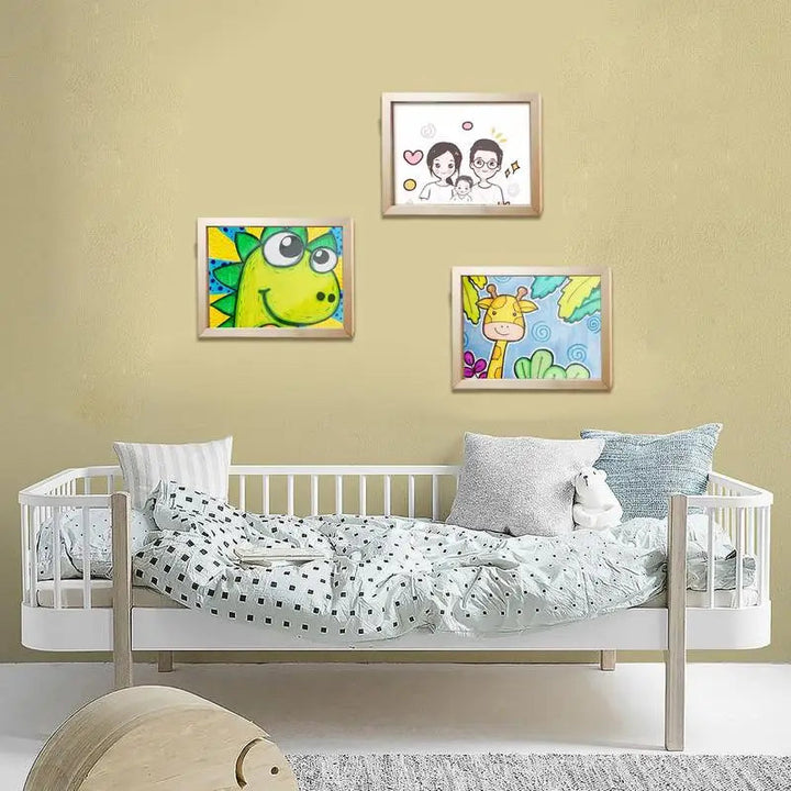 Three wooden art frames displaying drawings above a child&