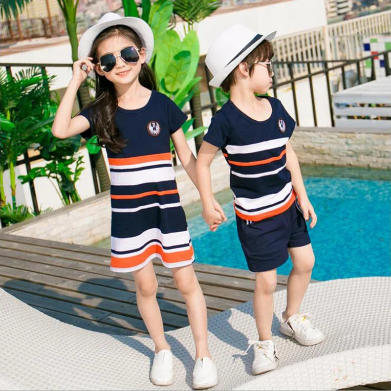 Two children holding hands in a navy striped dress and matching T-shirt with shorts