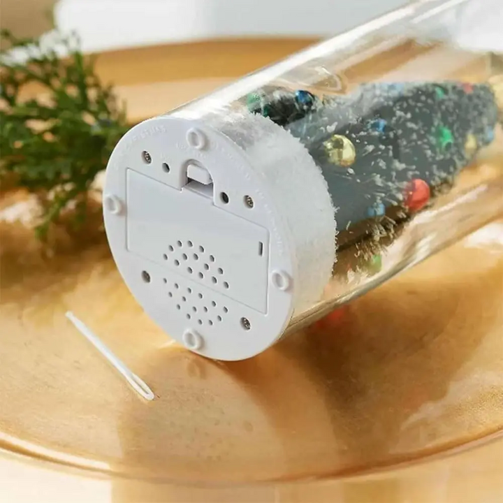 Underside of the Christmas message bottle showing the battery cover, speaker grille, and controls