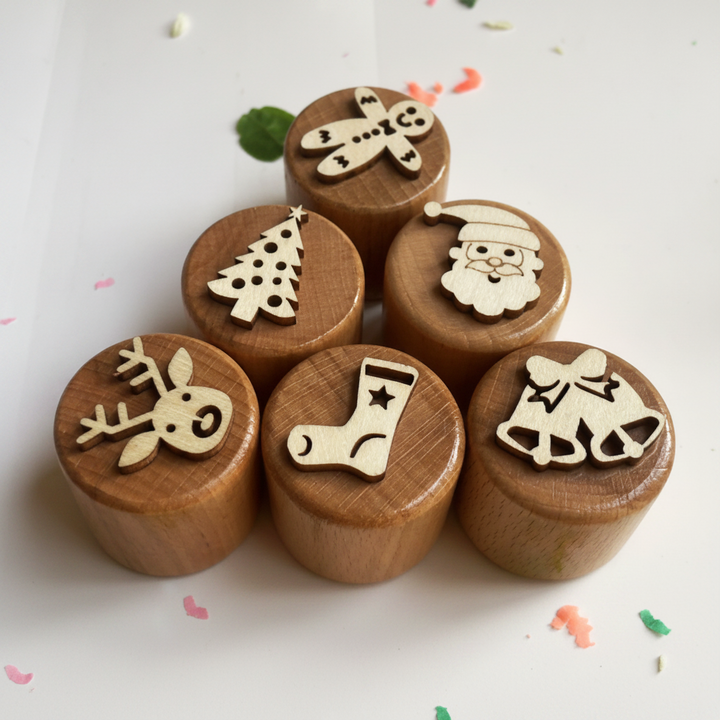 Six Christmas wooden clay stamps with tree, Santa, reindeer, stocking, gingerbread, and bell designs.