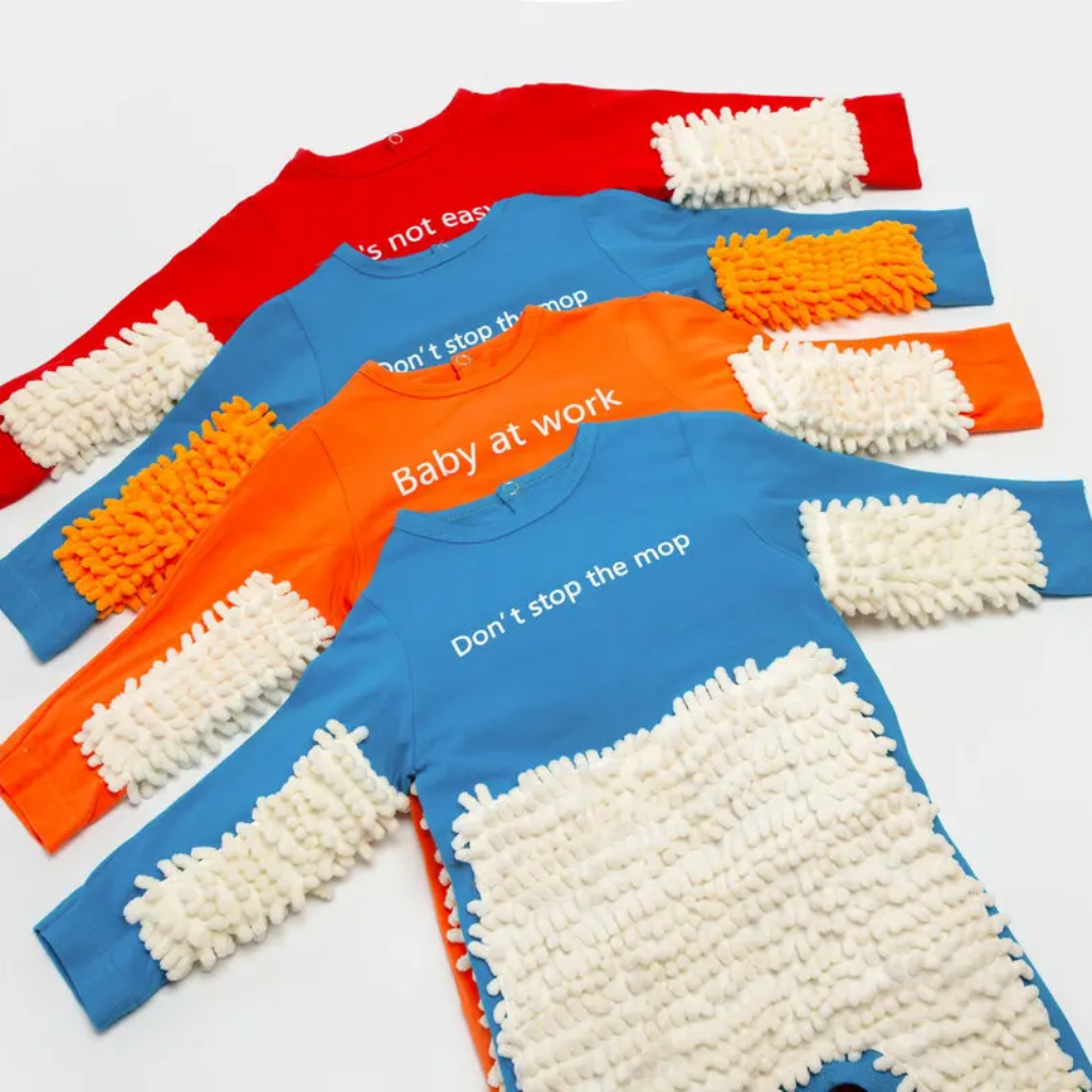 Blue, orange, and red baby jumpsuits laid flat with white or orange fiber panels