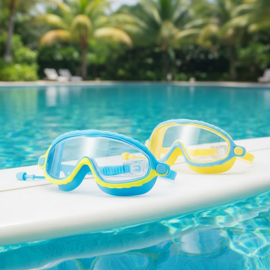 Blue-and-yellow swimming goggles with clear lenses resting on the edge of a pool