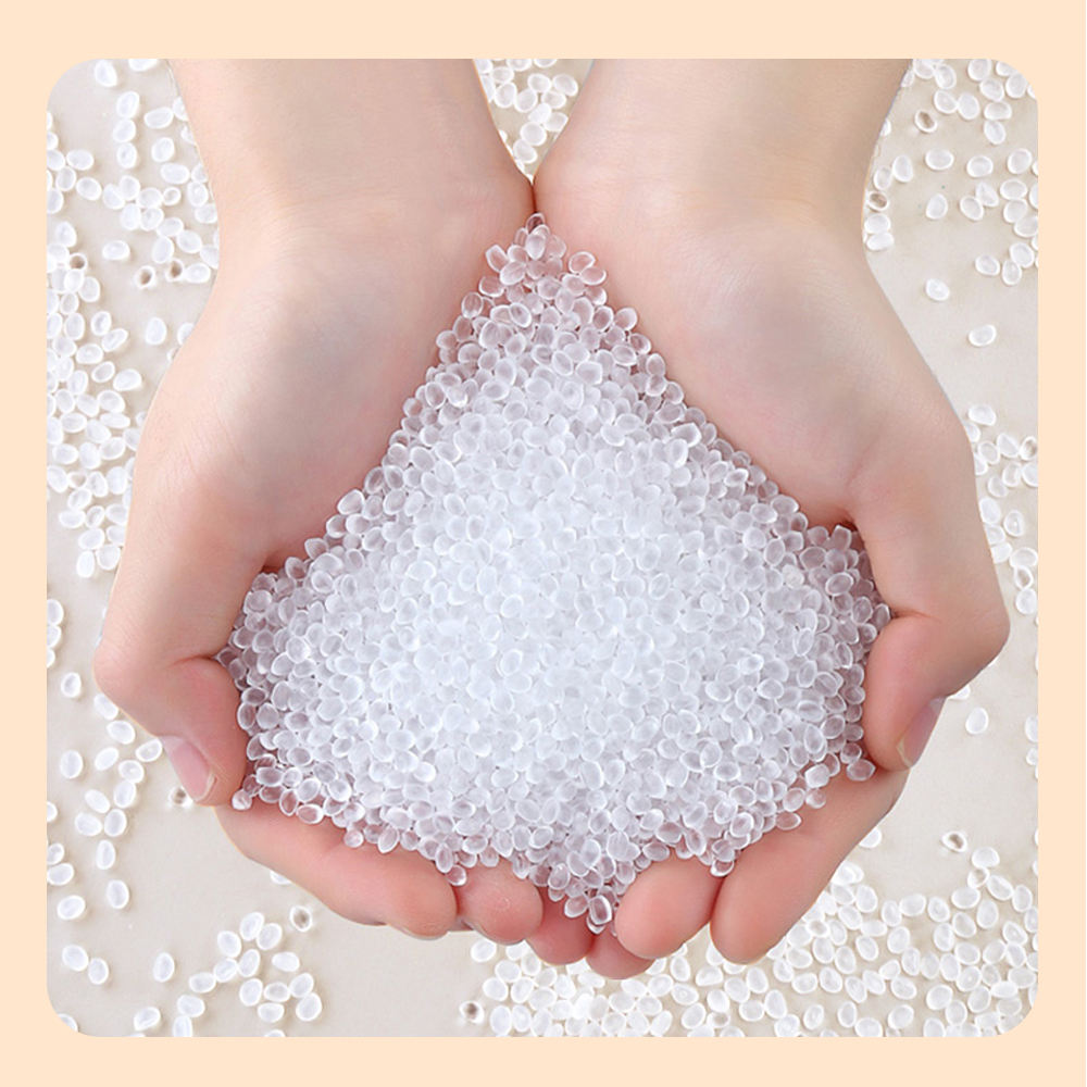Hands holding clear plastic pellets