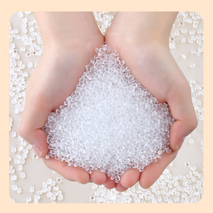 Hands holding clear plastic pellets