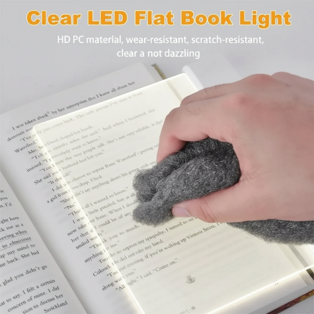 Clear LED reading panel being wiped with a cloth over an open book