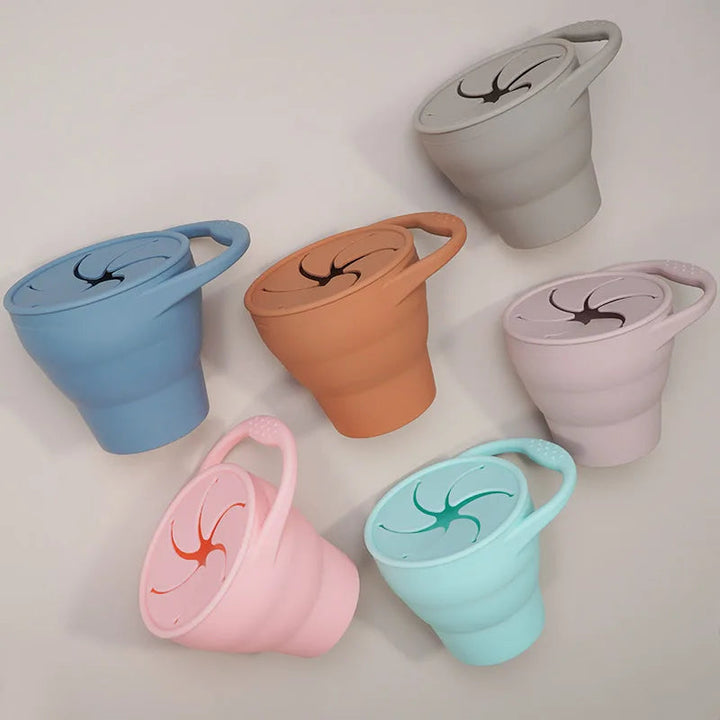Six collapsible silicone snack cups showing their loop handles and flexible openings