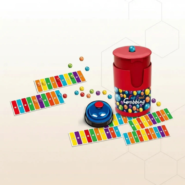 Color-matching cards and loose play balls arranged around a red container and blue bell