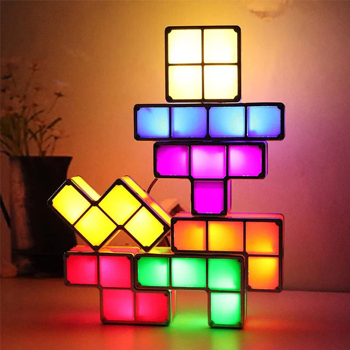 Seven multicolored LED blocks stacked into a glowing night light on a tabletop.