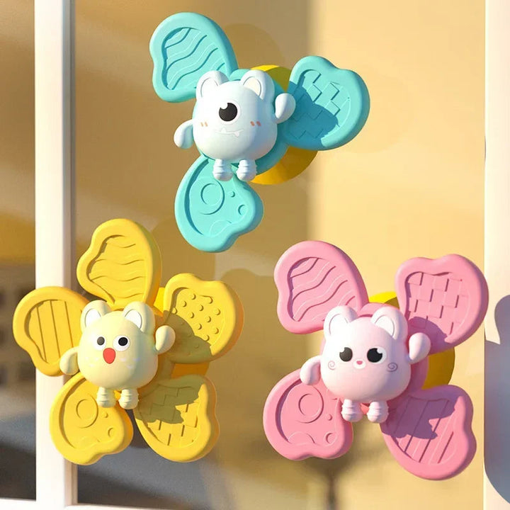 Mint, yellow, and pink animal spinners mounted on a smooth vertical surface