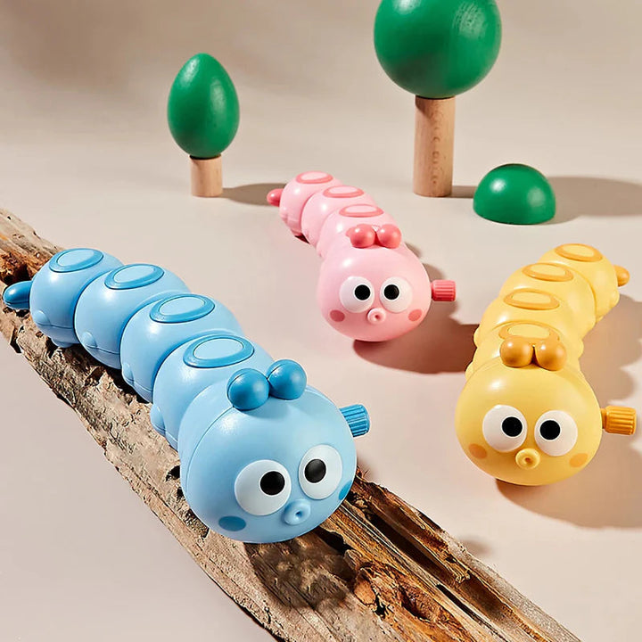 Blue, pink, and yellow segmented caterpillar toys in a woodland-style display