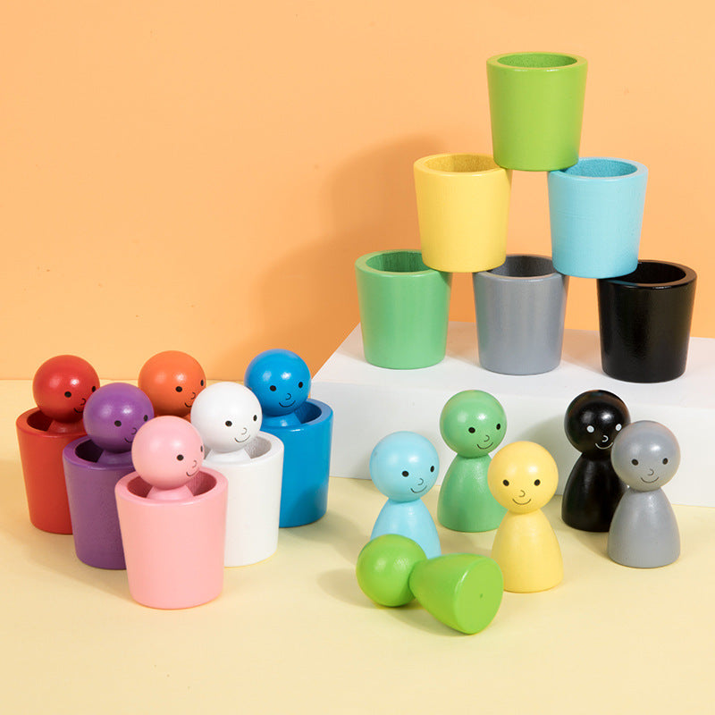 Colorful wooden sorting figures and cups arranged beneath a stacked cup pyramid