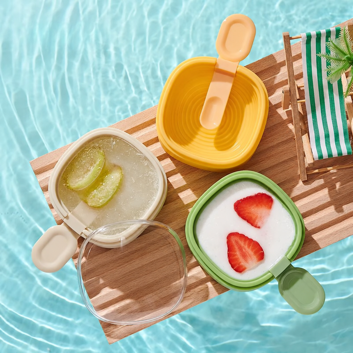 White, green, and yellow ice cream molds with matching spoons and fruit-filled frozen treats.